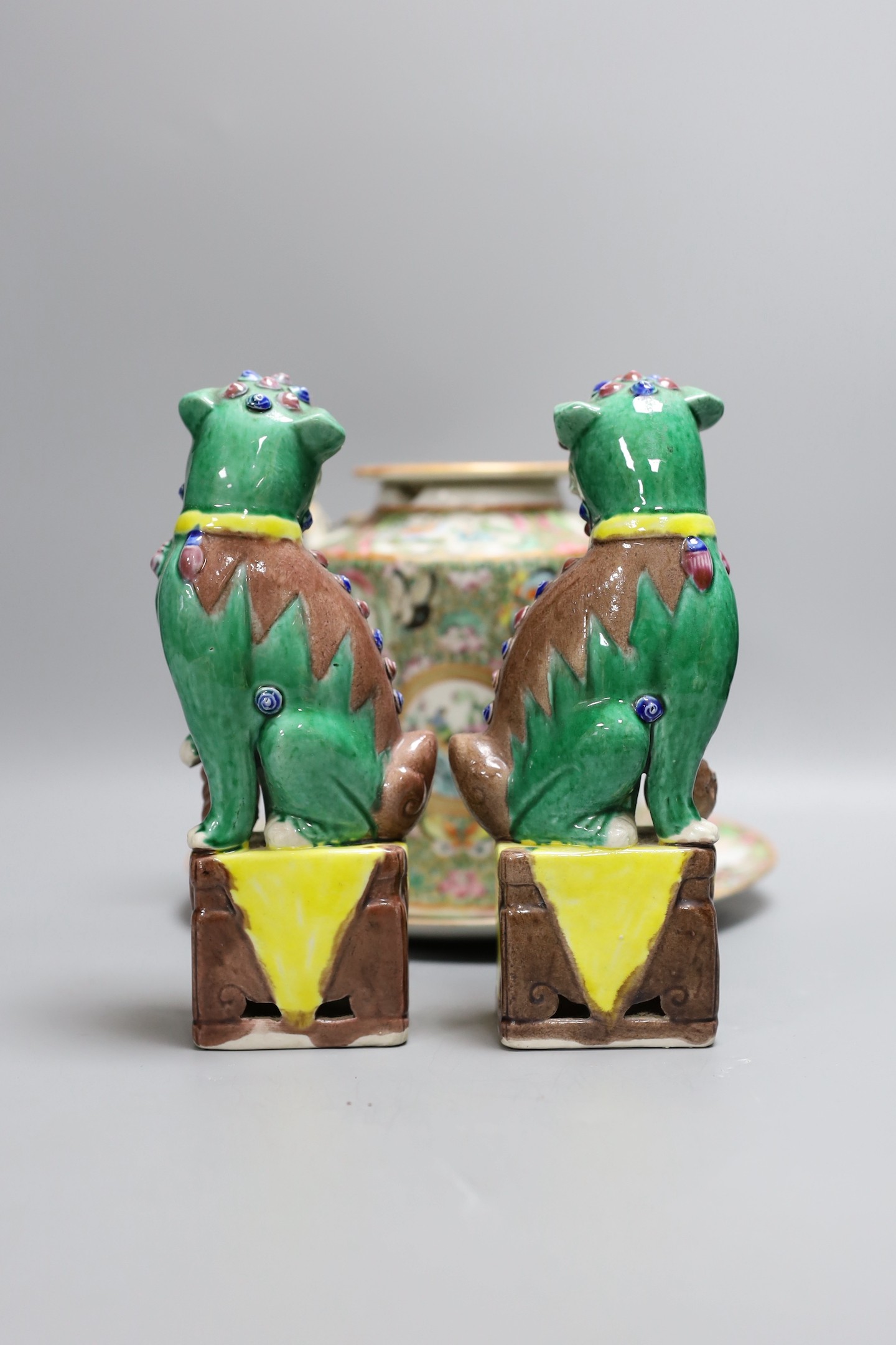 A Cantonese famille rose plate and teapot with cover, a pair of Chinese seated dogs, and a tureen with cover and oval dish, And a Chinese faux lacquer dragon and Phoenix dish, teapot 18 cms high